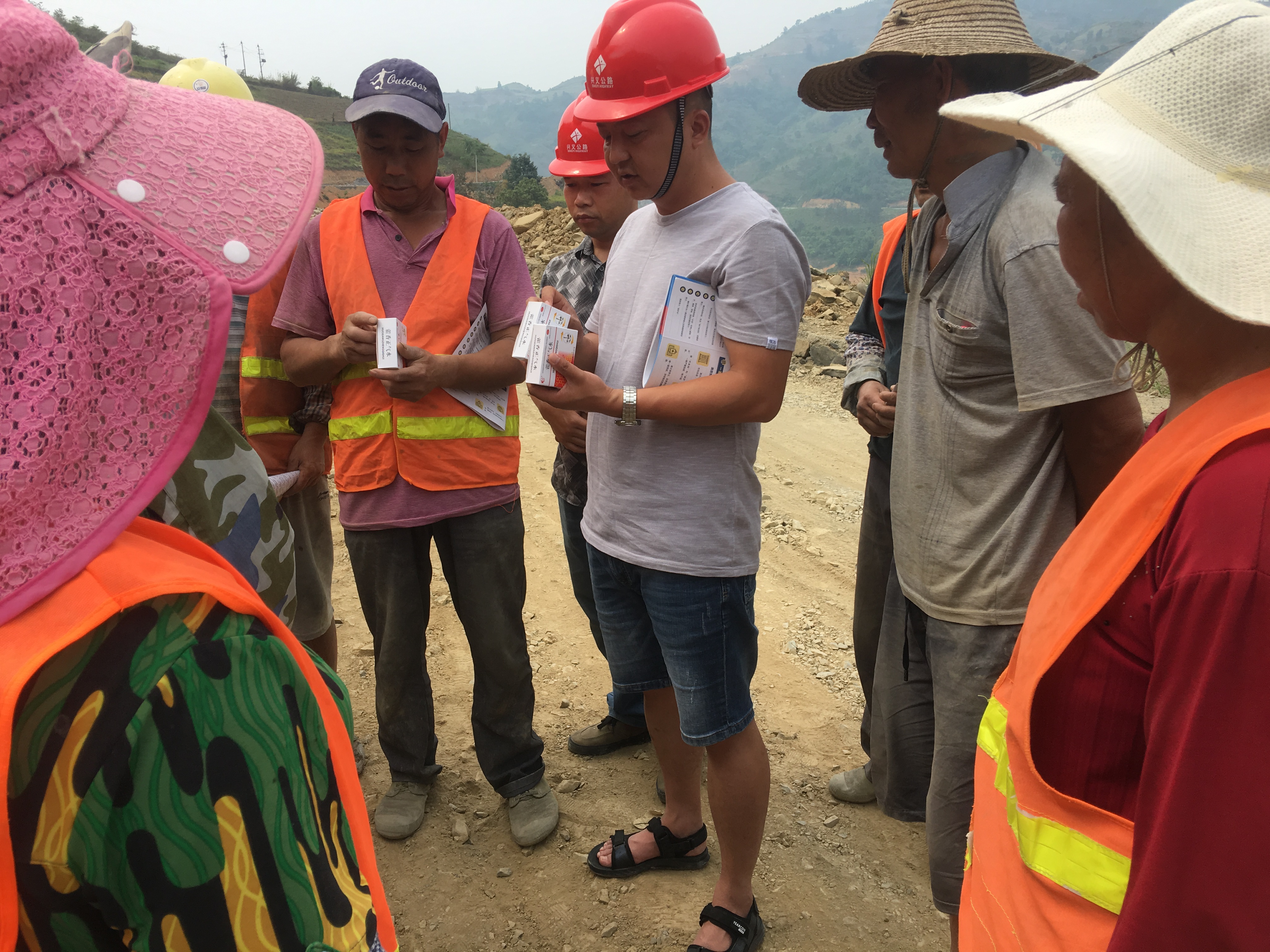 1557204103463041837.jpg 项目部工作人员正在为务工人员发放防暑药品.jpg