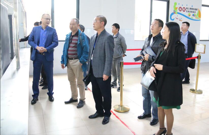 1557459451765097280.jpg 食堂管理负责人向调研组一行介绍取餐区.jpg