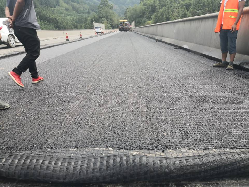 1567996241823045956.jpg 图2、压实完后工程人员又在刚铺好的沥青路面上盖上一层土工格栅.jpg