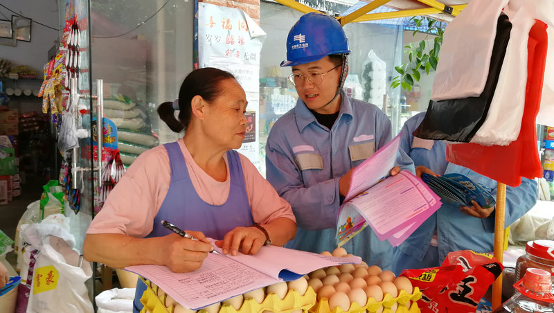 1591928346102084783.jpeg 工作人员向摊贩宣传安全用电.jpeg