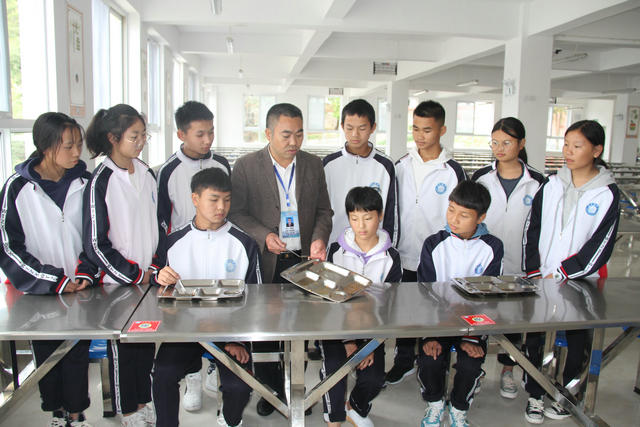7   李源洲老师在食堂给学生讲”节约粮食”的重要性.jpg