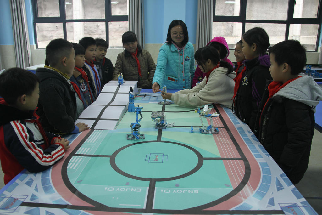 4.陈书琦老师在指导新市民学生搭建机器人.jpg