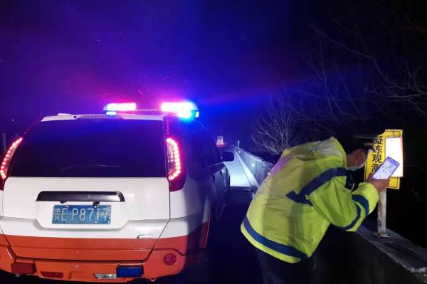 图8：九支队交通执法人员深夜查看易凝冻路段气温（董学忠摄）(1).jpg