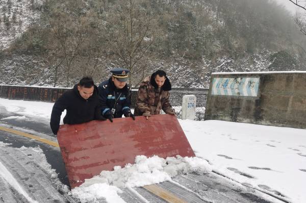 图11：九支队交通执法人员和被堵的驾乘人员一起用大木板铲雪（何明庆摄）(1).jpg